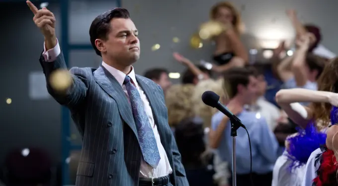 Leonardo DiCaprio gestures confidently in suit at party scene