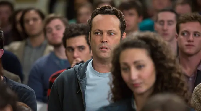 Vince Vaughn in gray hoodie looks sideways in crowded room