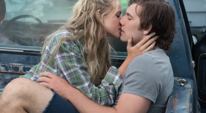 young couple kissing passionately in the bed of a rusty truck
