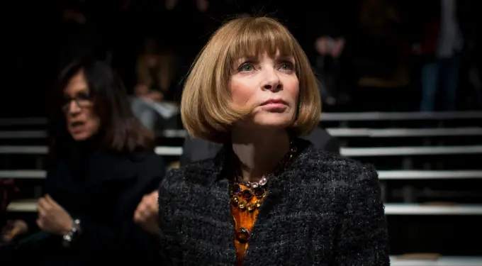 Fashion editor Anna Wintour looks thoughtfully ahead in dark setting