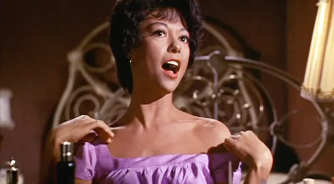 Rita Moreno singing in purple dress on West Side Story movie scene