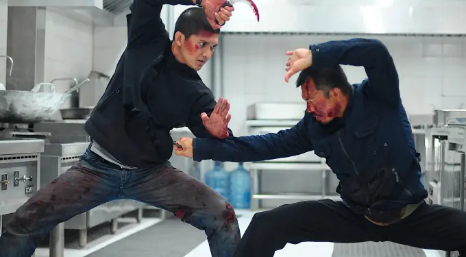 Two men with bloodied faces fight fiercely in kitchen scene