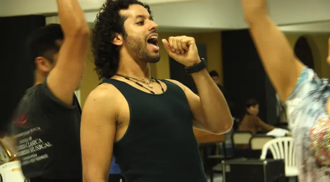 Luis Salgado singing energetically in rehearsal setting