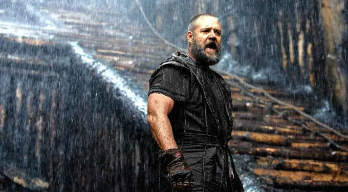 Bearded man shouting under heavy rain in dark costume and gloves