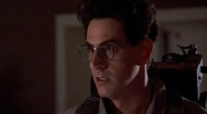 Harold Ramis in Ghostbusters gear looking to side with glasses