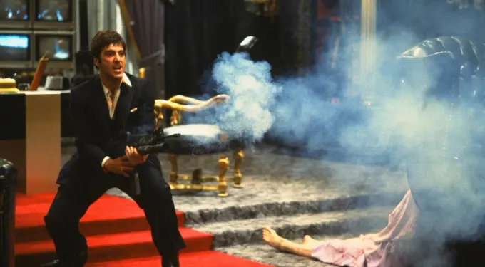 Al Pacino firing a gun in a violent scene from Scarface