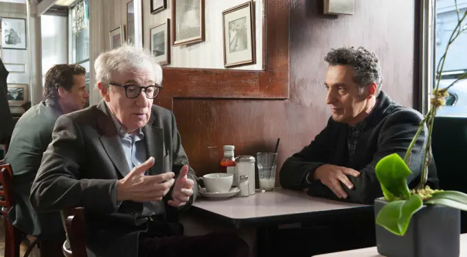 Woody Allen seated at diner table talking to man across from him