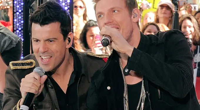 Nick Carter and Jordan Knight sing on stage during live performance