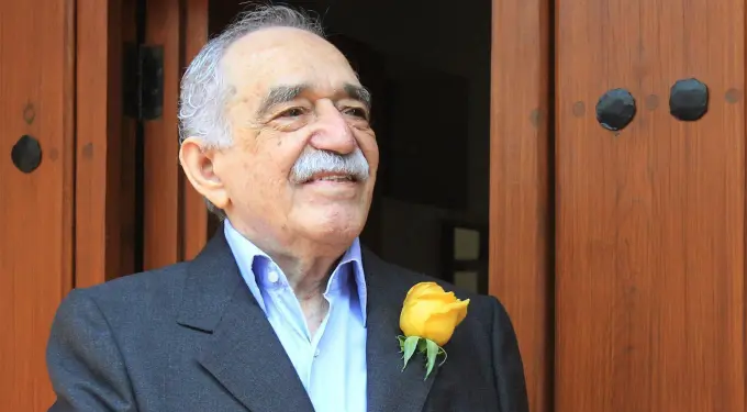 Gabriel García Márquez in suit with yellow rose on wooden door background