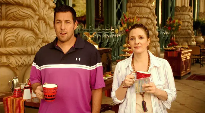 a man and woman holding red mugs indoors with ornate background