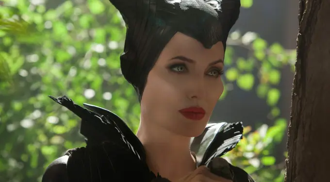 Angelina Jolie as Maleficent with horns and dark costume in forest