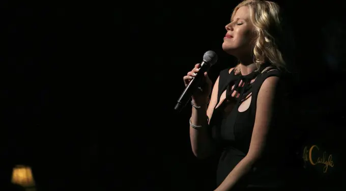 Megan Hilty singing into microphone on stage at Café Carlyle