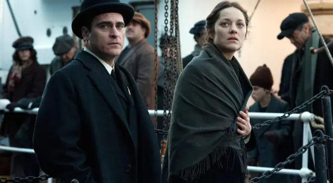 man in bowler hat and woman wrapped in shawl on ship deck