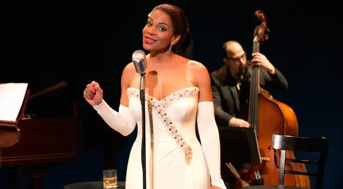 Audra McDonald singing as Billie Holiday with upright bass player behind