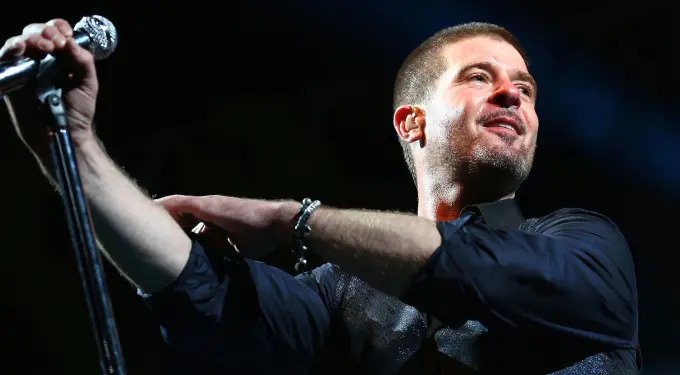 Robin Thicke sings into microphone during London festival performance