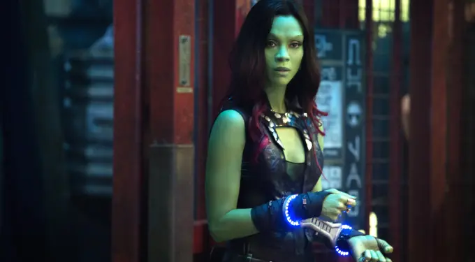 Zoe Saldana as green-skinned Gamora holding glowing wrist weapons