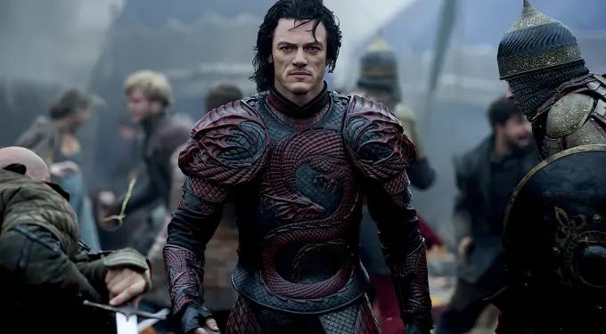 actor in red dragon armor stands serious in medieval battle camp