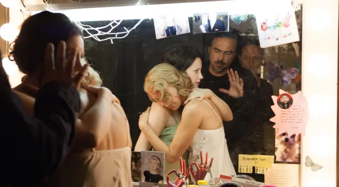Naomi Watts and Andrea Riseborough hug as director Iñárritu watches in mirror