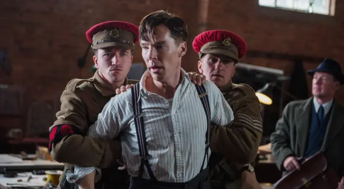 Man in suspenders restrained by two soldiers wearing brown uniforms