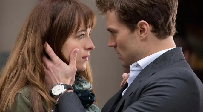 man in suit holding woman’s face during romantic moment in movie