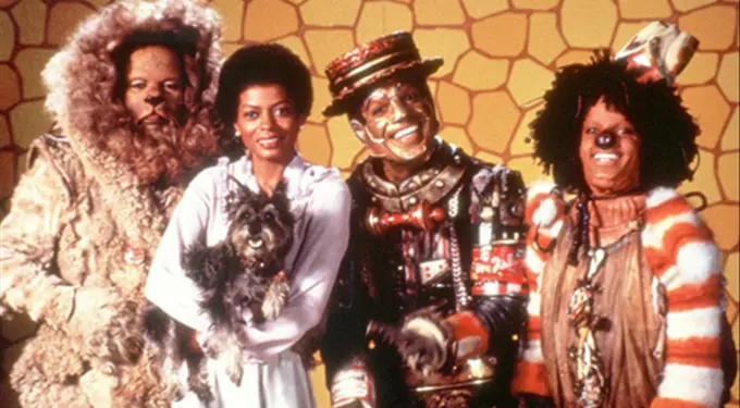 Four actors in The Wiz costumes, woman holding small dog