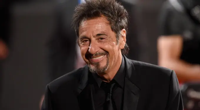 Al Pacino in black suit smiling at premiere event