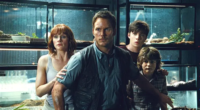 Four tense characters stand in front of glass tanks, one man protective