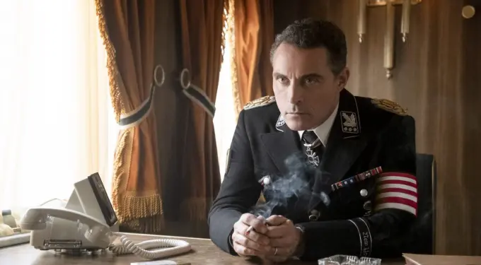 Man in Nazi uniform sitting at desk smoking a cigarette