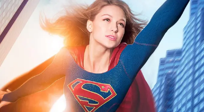 Supergirl flying upward in costume with cape and sunlight behind