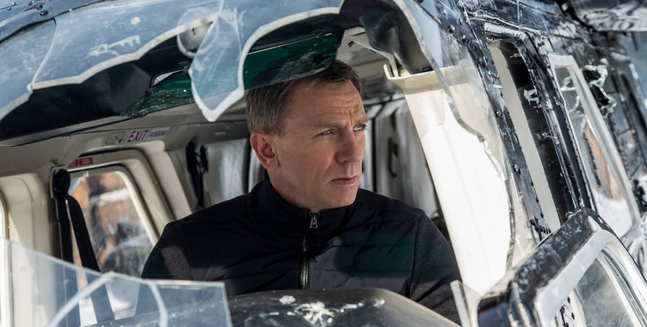 Daniel Craig as James Bond sits inside a damaged cockpit in Spectre