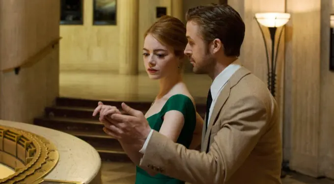 Ryan Gosling and Emma Stone in formal clothes sharing a close moment