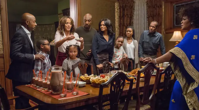 Family gathered around dining table filled with food in a warm home