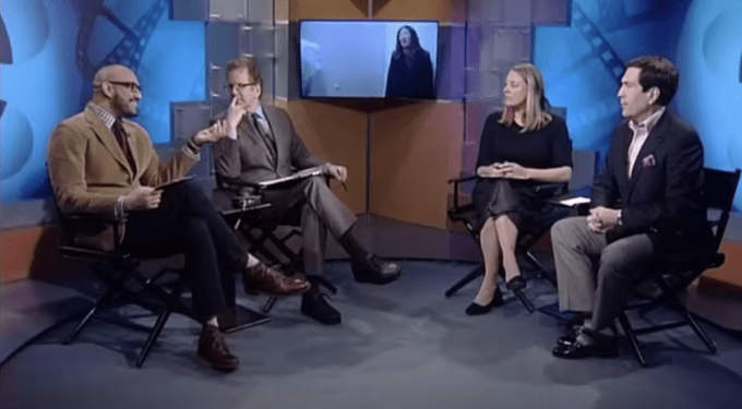 Four people seated in TV studio chairs engaged in discussion