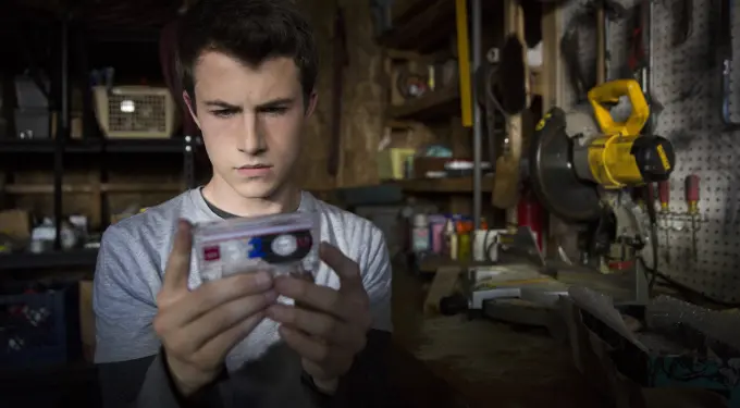 Young man in workshop focusing on an audio cassette tape