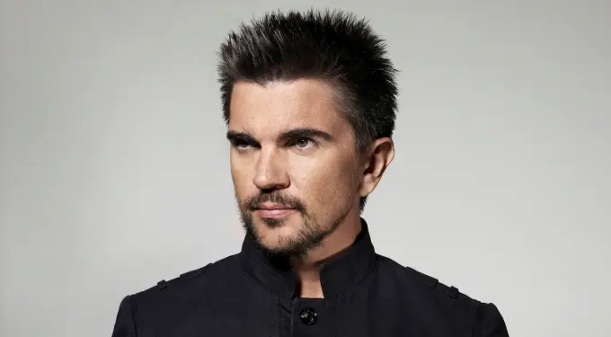 Colombian singer Juanes in black jacket looking sideways
