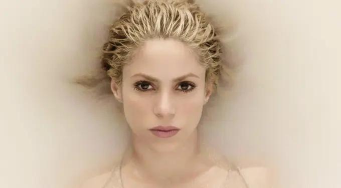 Shakira close-up headshot submerged in milky water with intense gaze