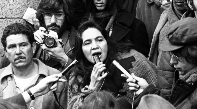 Dolores Huerta speaking into microphone at 1975 press conference