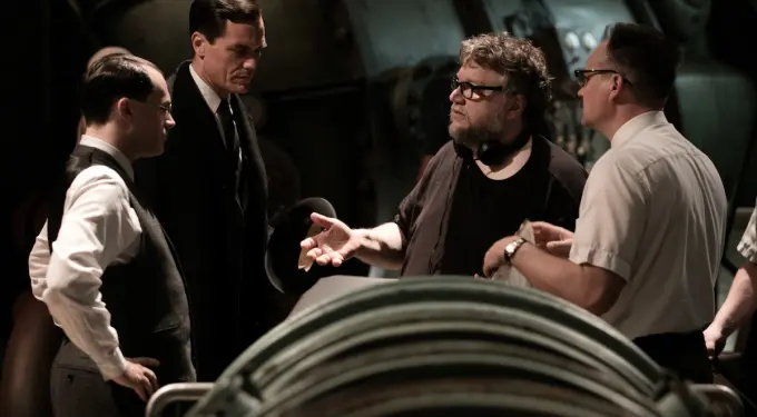 Guillermo del Toro discussing scene with men in period costumes