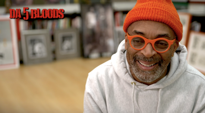 Spike Lee in orange hat and glasses smiling during interview