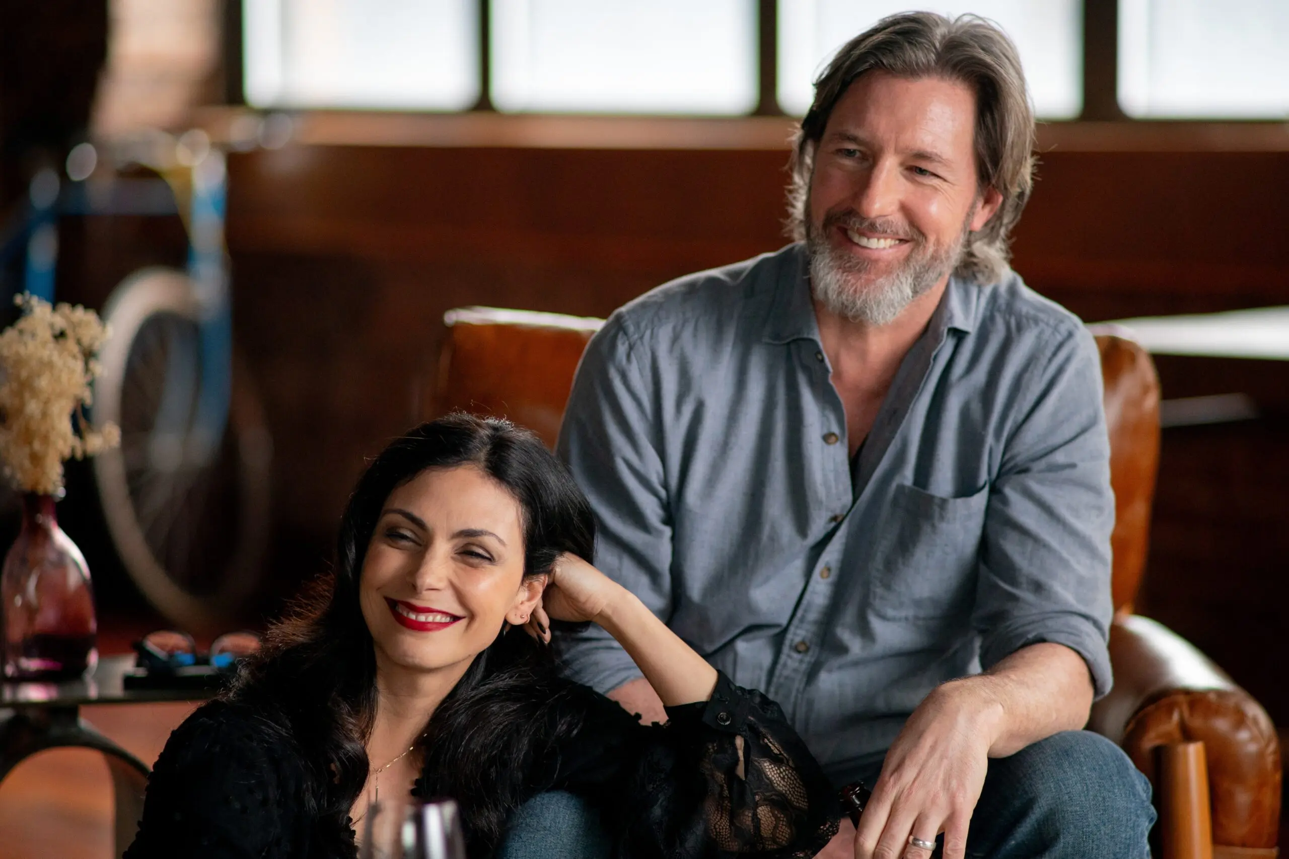smiling man with beard and woman with red lipstick indoors